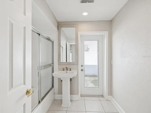 a bathroom with a granite countertop sink a shower and a mirror