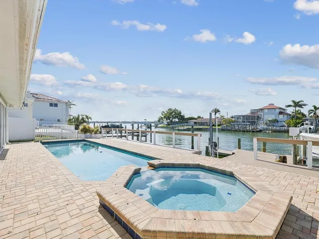 a view of a swimming pool with a patio and a yard