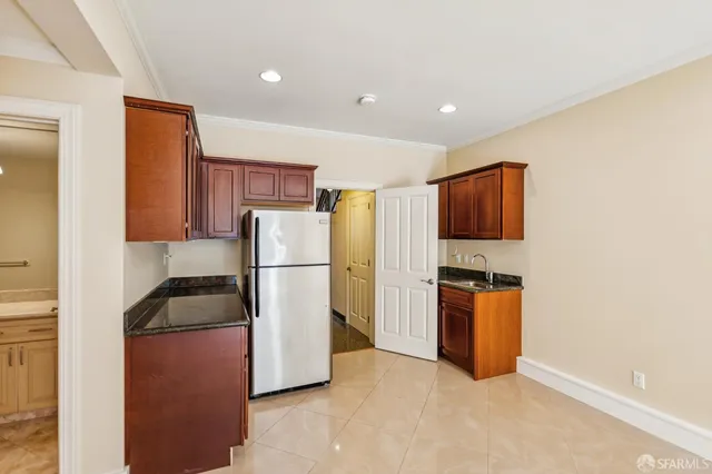 a kitchen with stainless steel appliances granite countertop a refrigerator a sink dishwasher a oven and a dining table with wooden floor