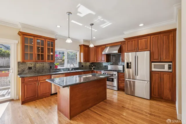 a large kitchen with stainless steel appliances kitchen island granite countertop a large kitchen island a stove and a sink