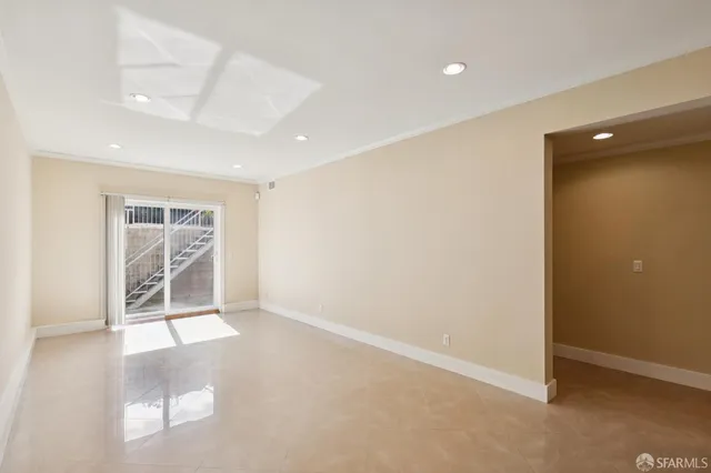 a view of an empty room with wooden floor fireplace and a window