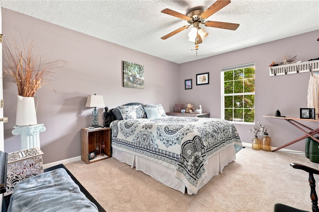 1009 Willow Run Anderson, SC 29621 - Photo 20 of 46 A spacious bedroom features soft neutral walls, classic carpeting, and views of mature outdoor greenery.
