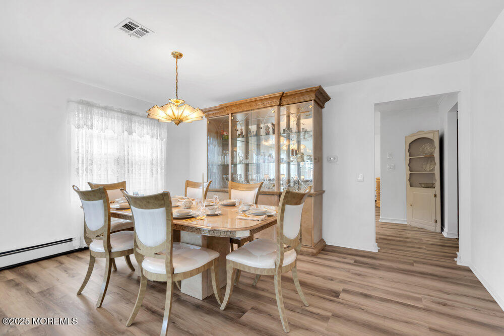 148 Davenport Road Toms River, NJ 08757 - Photo 14 of 49 a dining room with wooden floor a chandelier a wooden table and chairs