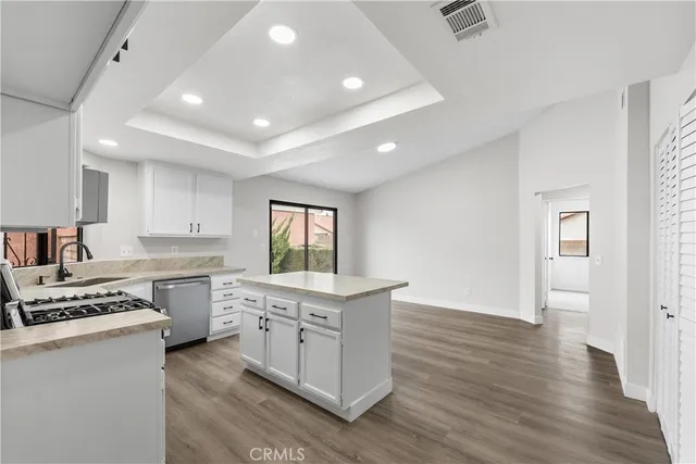 a kitchen that has a lot of cabinets in it and wooden floors