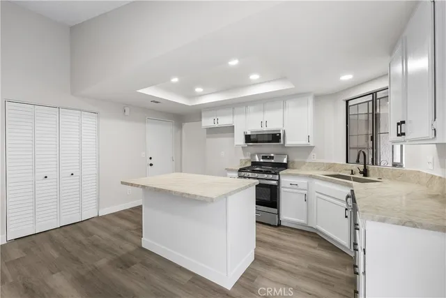 a kitchen with stainless steel appliances kitchen island granite countertop a stove a sink and a refrigerator