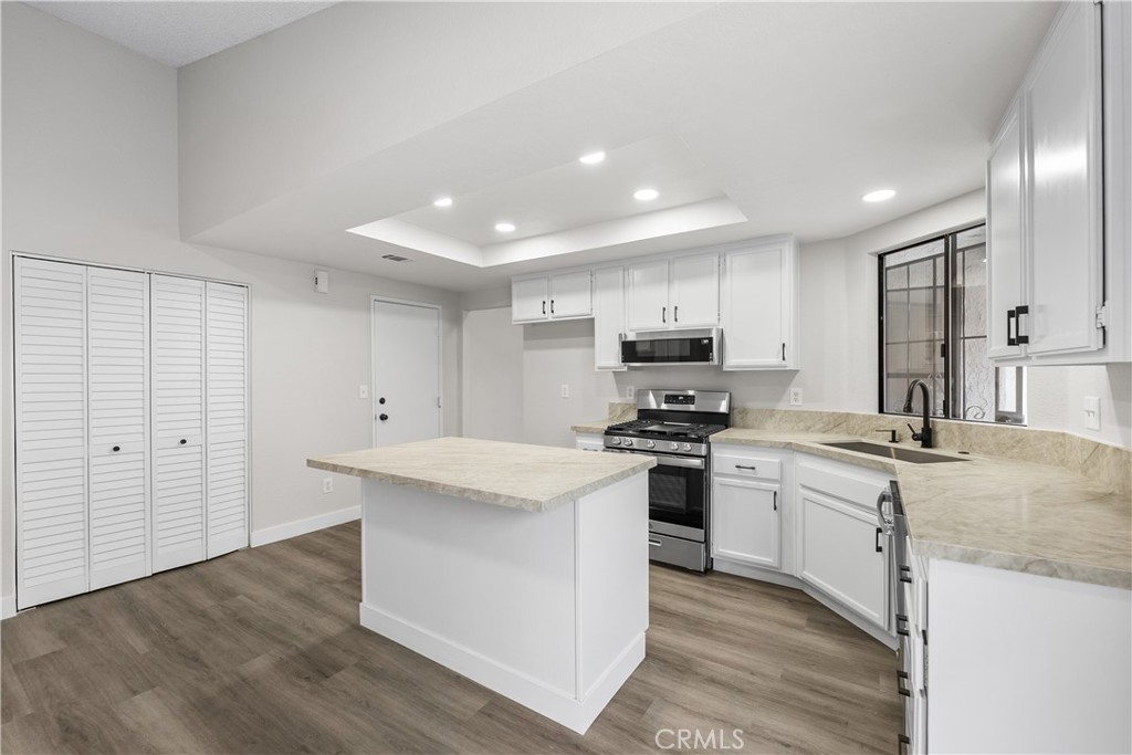 3563 East Ave R-11 Palmdale, CA 93550 - Photo 14 of 36 a kitchen with stainless steel appliances kitchen island granite countertop a stove a sink and a refrigerator