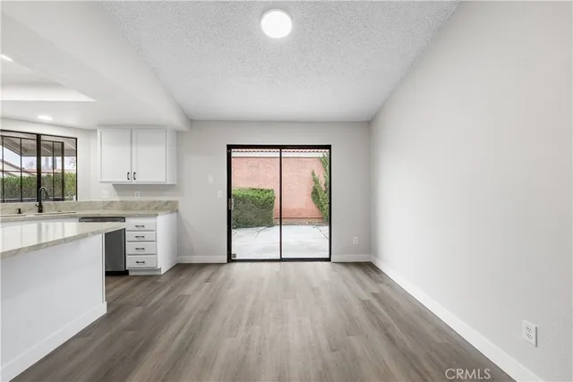 a open kitchen with a large window a sink and white appliances