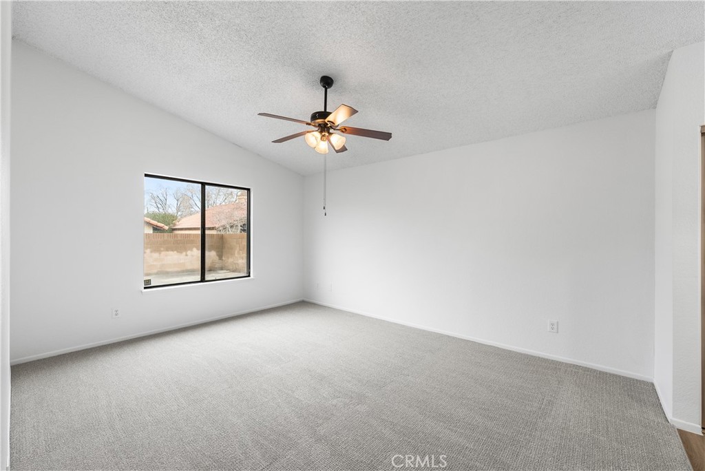 3563 East Ave R-11 Palmdale, CA 93550 - Photo 21 of 36 an empty room with windows and chandelier fan