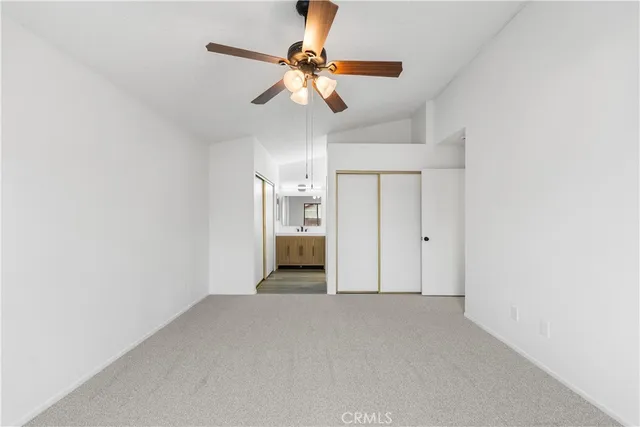 a view of a room with a ceiling fan and window
