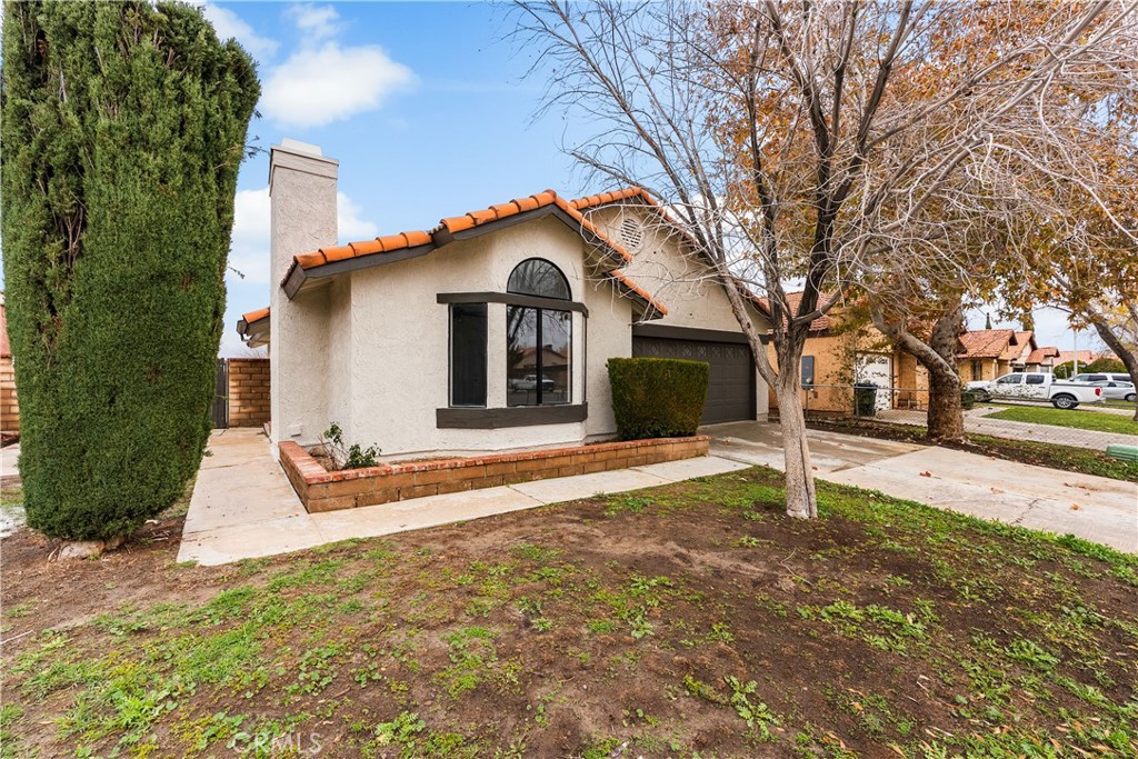 3563 East Ave R-11 Palmdale, CA 93550 - Photo 4 of 36 a front view of a house with a yard and garage