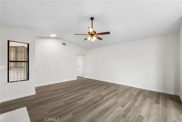 a view of a room with wooden floor and a ceiling fan