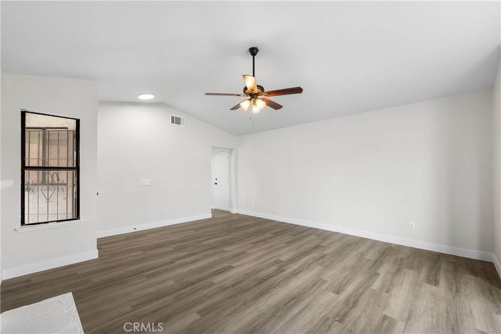 3563 East Ave R-11 Palmdale, CA 93550 - Photo 9 of 36 a view of a room with wooden floor and a ceiling fan