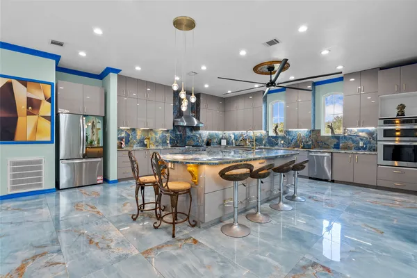 a kitchen with stainless steel appliances kitchen island granite countertop a sink and cabinets
