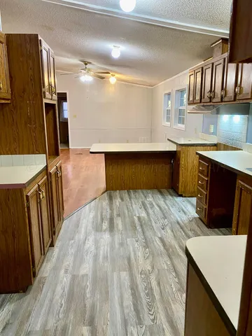 a living room with stainless steel appliances kitchen island granite countertop a refrigerator stove and sink