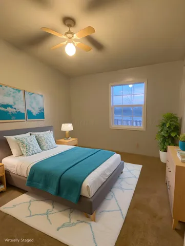 a bedroom with a bed lamp and a large window