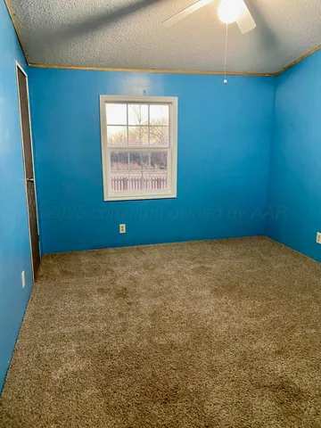 a view of an empty room with a fireplace and a window
