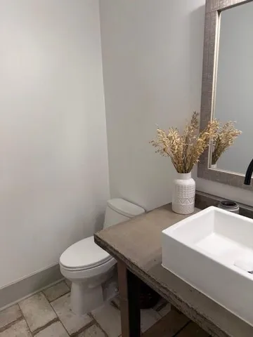 a bathroom with a sink a toilet and a mirror