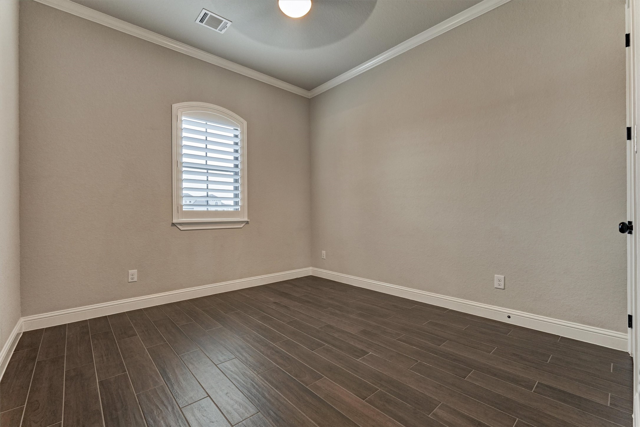 11618 Renaissance Drive Montgomery, TX 77356 - Photo 25 of 49 The guest bedroom on the first floor has wood look tile flooring, crown molding and a custom window shutter. This room overlooks the front of the home.