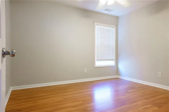 an empty room with wooden floor and window