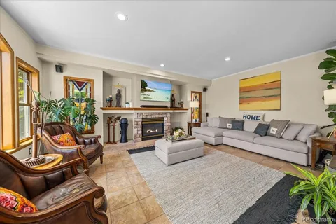 a living room with furniture a large window and a fireplace