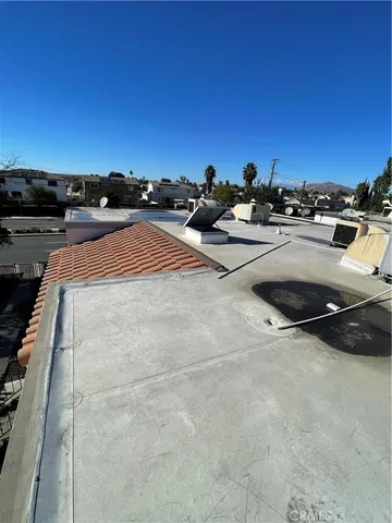 a backyard of a house with table and chairs under an umbrella