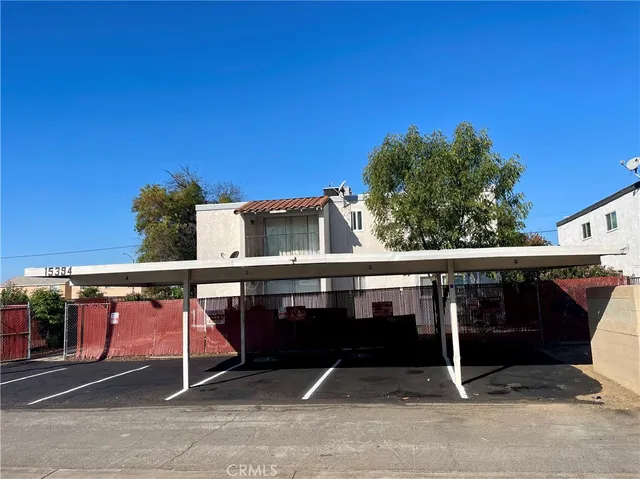 a view of a couch with white walls and dining area
