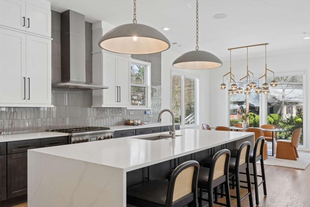 32 Walthall Street Northeast, Unit A Atlanta, GA 30307 - Photo 13 of 39 a kitchen with stainless steel appliances granite countertop a dining table chairs and white cabinets