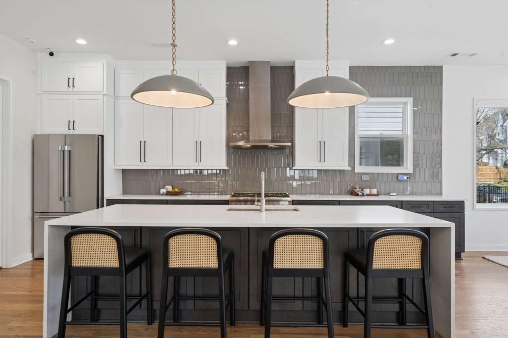 32 Walthall Street Northeast, Unit A Atlanta, GA 30307 - Photo 2 of 39 a kitchen with stainless steel appliances granite countertop a dining table chairs sink and white cabinets