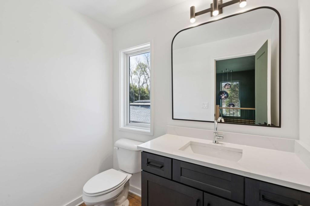 32 Walthall Street Northeast, Unit A Atlanta, GA 30307 - Photo 32 of 39 a bathroom with a toilet a sink a mirror and a window