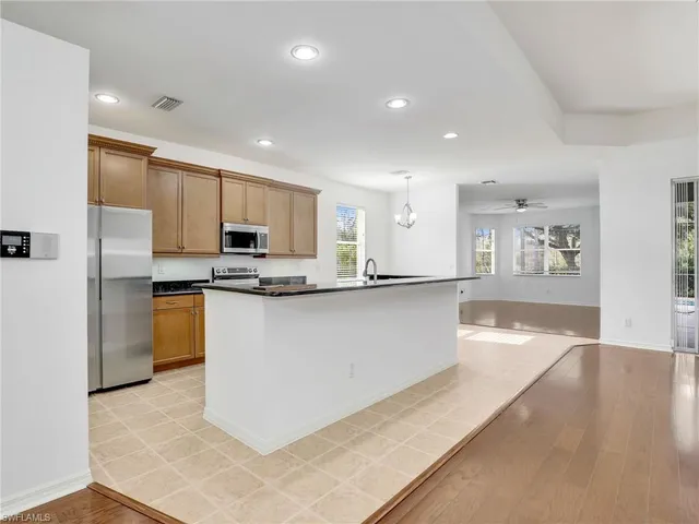 a kitchen with stainless steel appliances granite countertop a refrigerator a stove and a sink