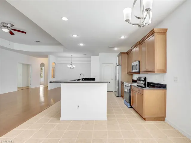 a kitchen with stainless steel appliances granite countertop a sink a stove top oven a counter space and cabinets