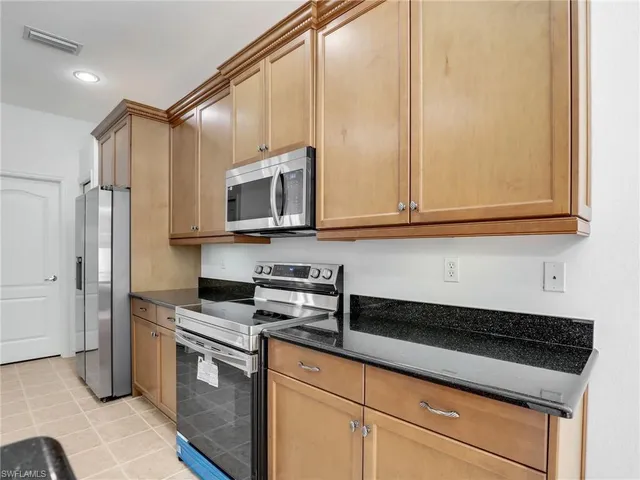 a kitchen with stainless steel appliances a cabinets and a stove top oven