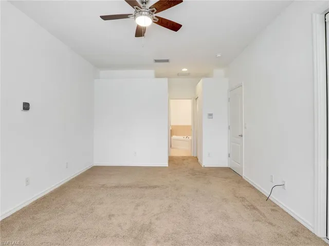 an empty room with a ceiling fan and a window