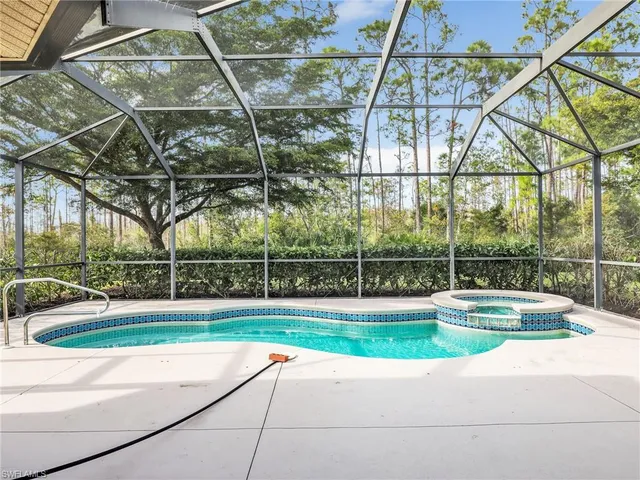 a view of a swimming pool with a yard and plants