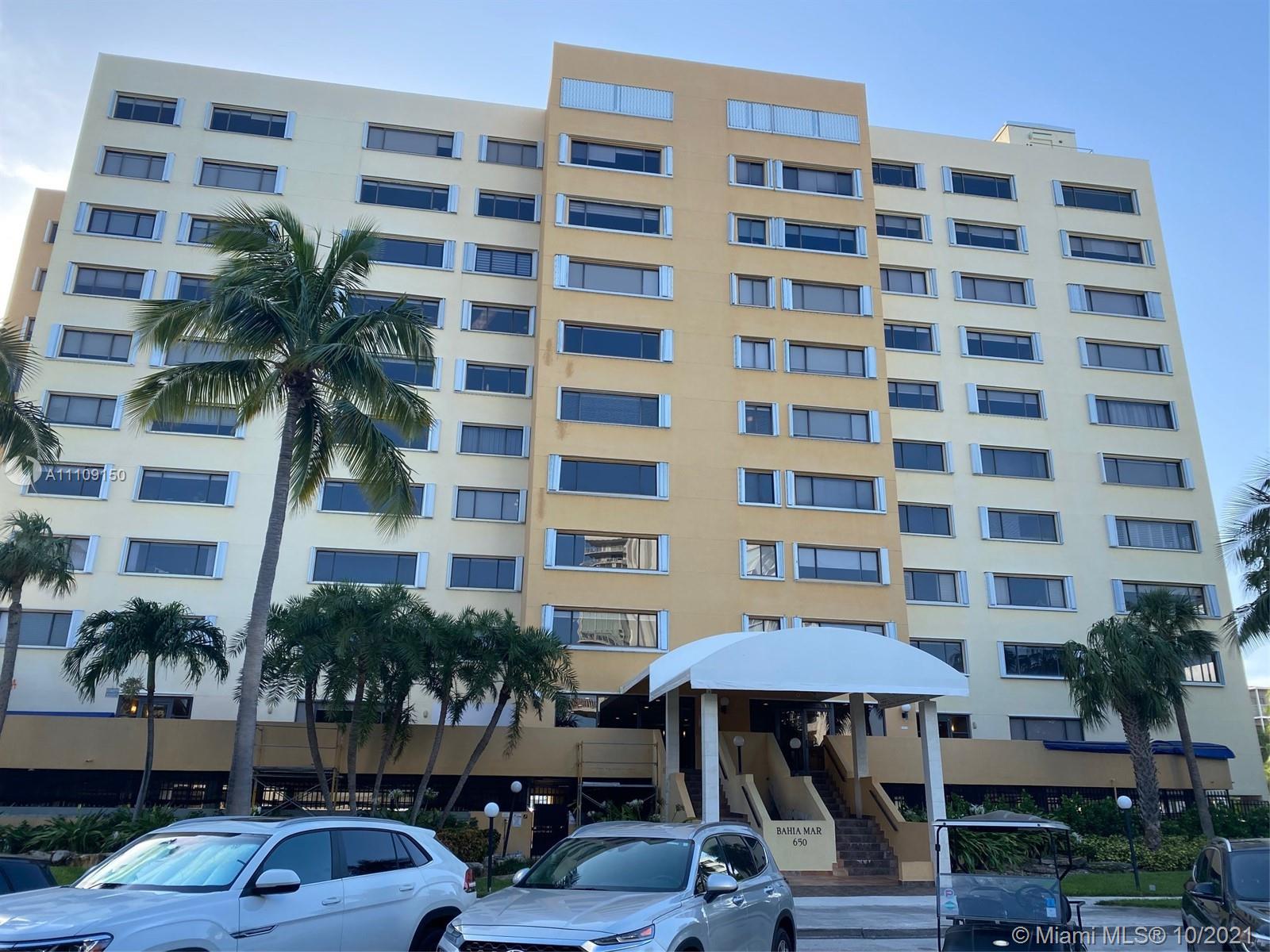 650 Ocean Drive, Unit 9E Key Biscayne, FL 33149 - Photo 5 of 5 a front view of building with yard and seating area