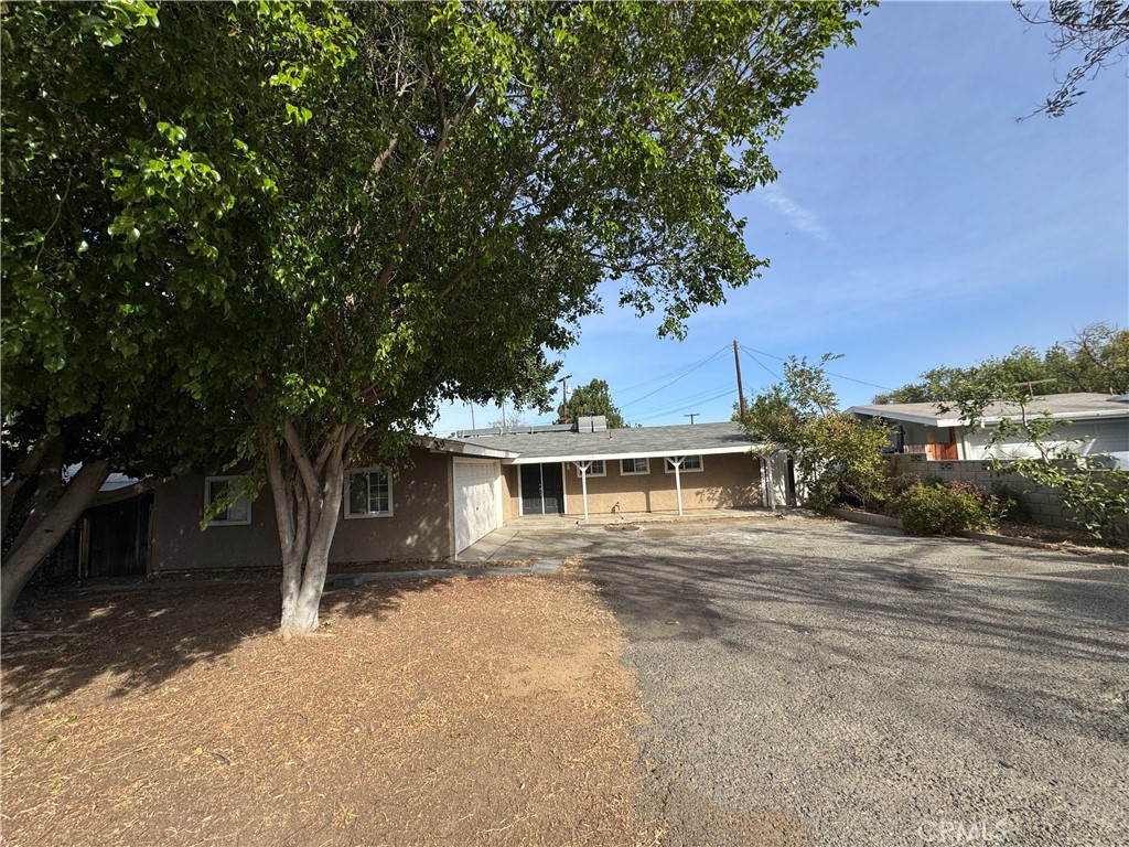 a front view of a house with a yard and trees