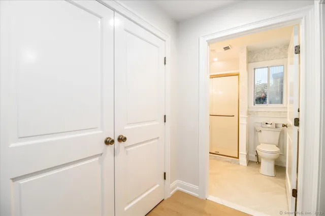 a bathroom with a granite countertop shower mirror and a toilet