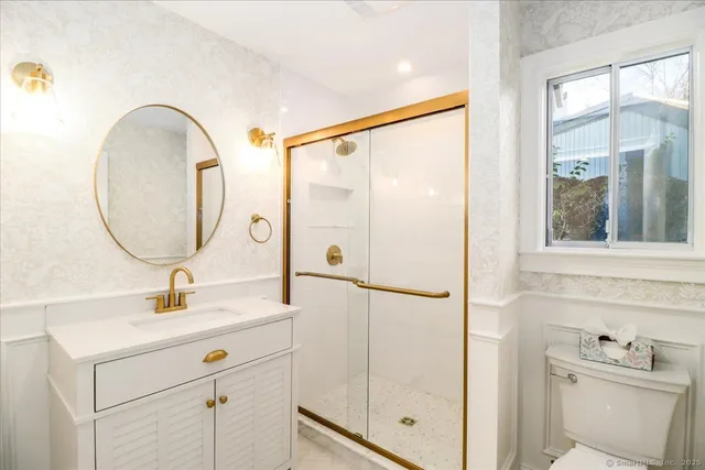 a bathroom with a sink mirror vanity and toilet