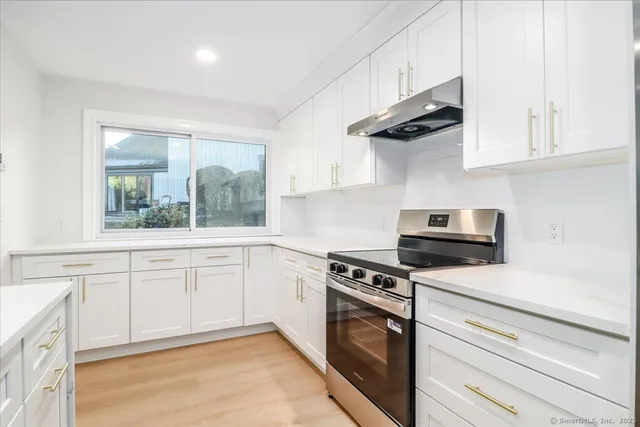 a kitchen with stainless steel appliances white cabinets and a stove