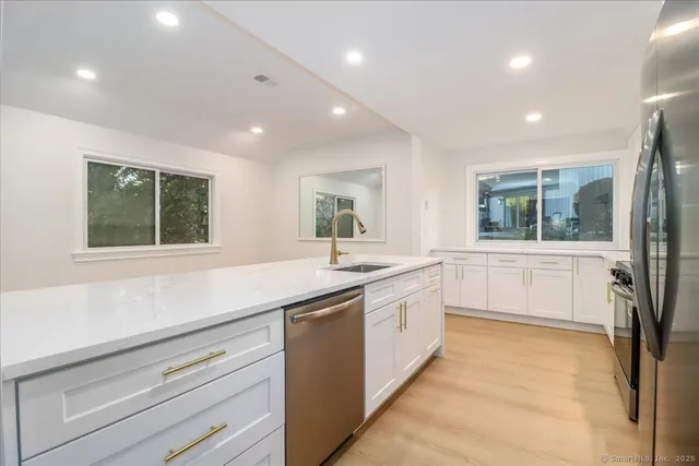a large white kitchen with a large window