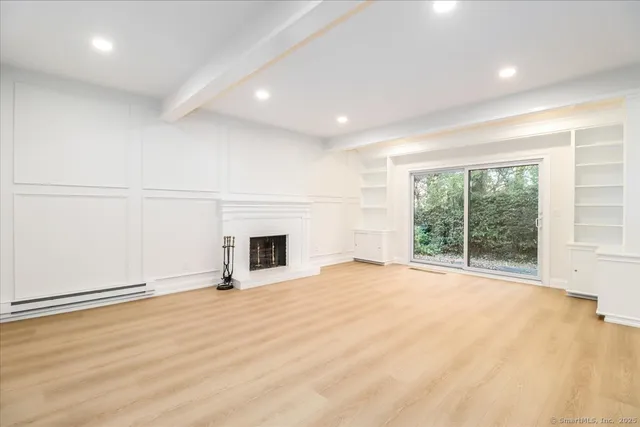 a view of an empty room with a fireplace and a window