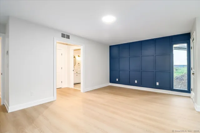 an empty room with cabinet and mirrors