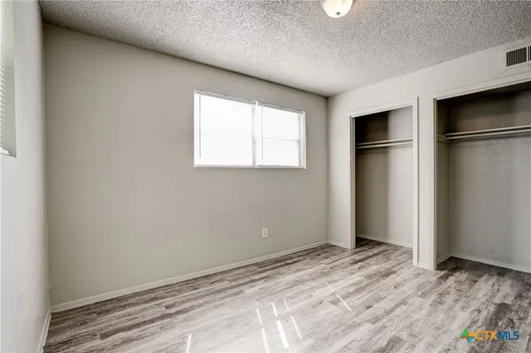 a view of empty room with wooden floor