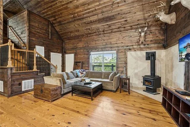 a living room with couches and kitchen view with wooden floor