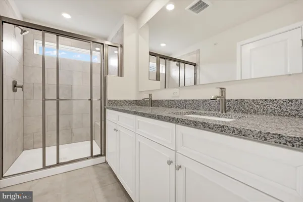 a bathroom with a granite countertop sink and mirror