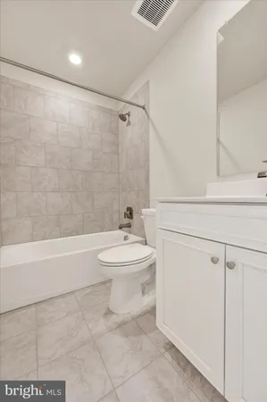a bathroom with a toilet a sink a mirror and bathtub