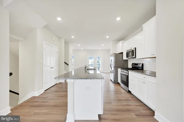 a large kitchen with kitchen island a stove a sink a refrigerator and cabinets