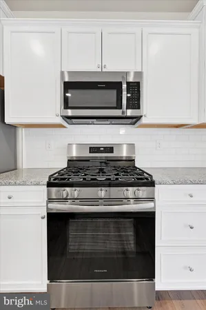 a stove top oven sitting inside of a kitchen