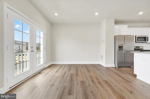 a view of empty room with wooden floor and windows