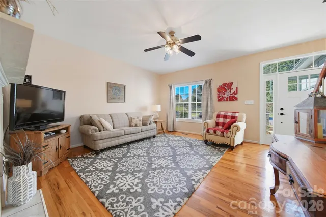 a open kitchen with stainless steel appliances granite countertop a stove top oven a sink a dining table and chairs with wooden floor